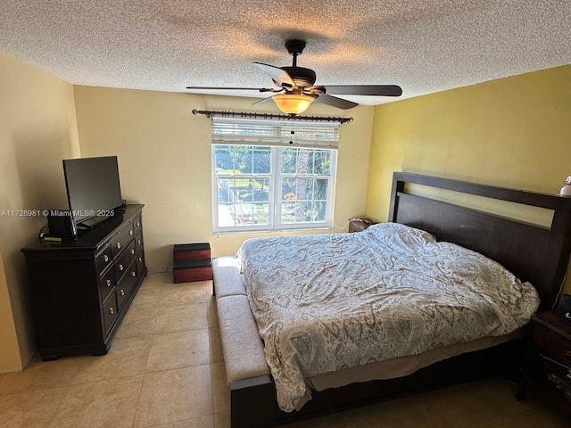 bedroom featuring light tile patterned flooring, ceiling fan, and a textured ceiling