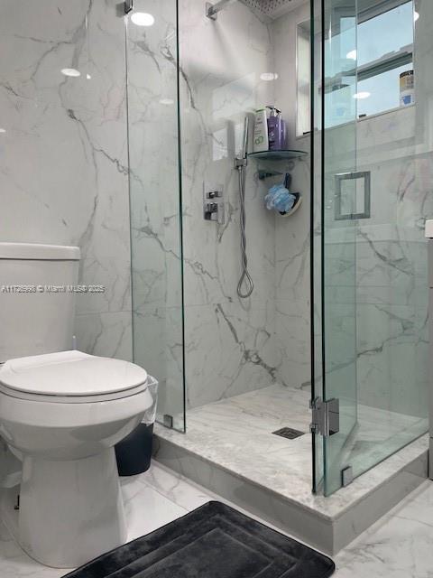 bathroom featuring an enclosed shower and toilet