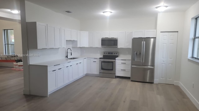 571 SE 37th Pl, Homestead, FL 33033 - kitchen featuring white cabinetry, sink, light wood-type flooring, and appliances with stainless steel finishes