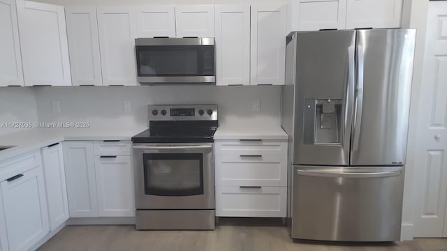 571 SE 37th Pl, Homestead, FL 33033 - kitchen featuring white cabinetry, light hardwood / wood-style flooring, and stainless steel appliances