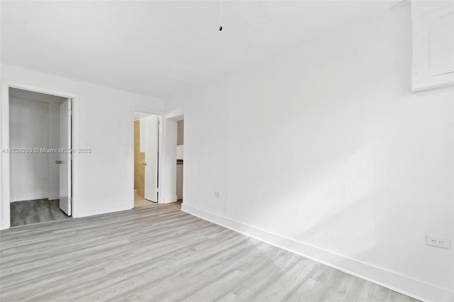 unfurnished bedroom featuring ensuite bath and light wood-type flooring