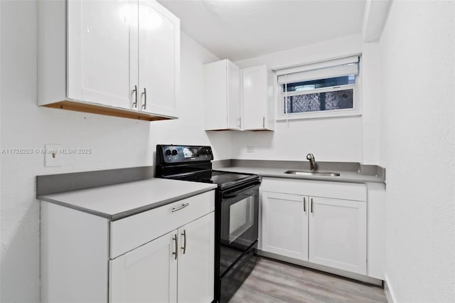 kitchen with white cabinets, light wood-type flooring, electric range, and sink