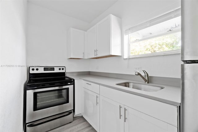 kitchen featuring light hardwood / wood-style floors, sink, stainless steel appliances, and white cabinetry