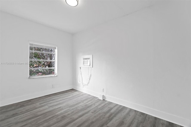 empty room with dark wood-type flooring and a wall mounted AC