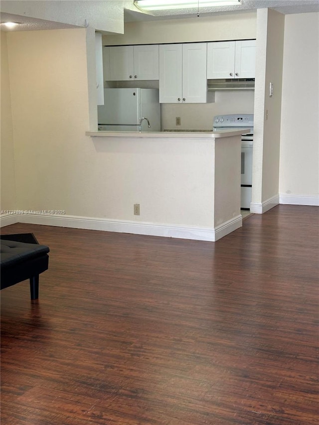 kitchen with white appliances, a textured ceiling, white cabinetry, dark hardwood / wood-style flooring, and sink