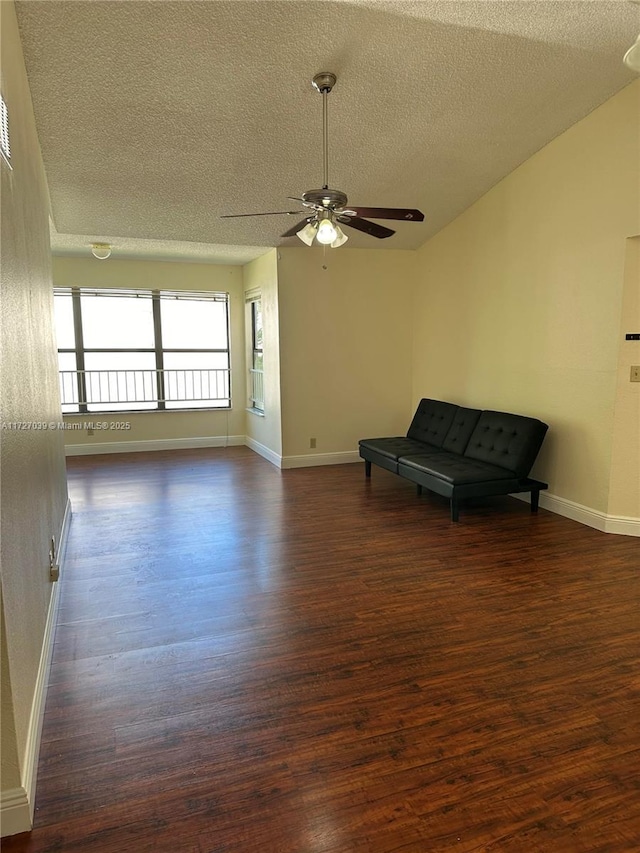 unfurnished room with a textured ceiling, ceiling fan, and dark hardwood / wood-style flooring