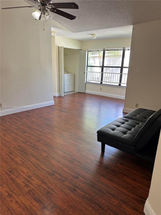 unfurnished living room featuring ceiling fan, dark wood-type flooring, and a textured ceiling