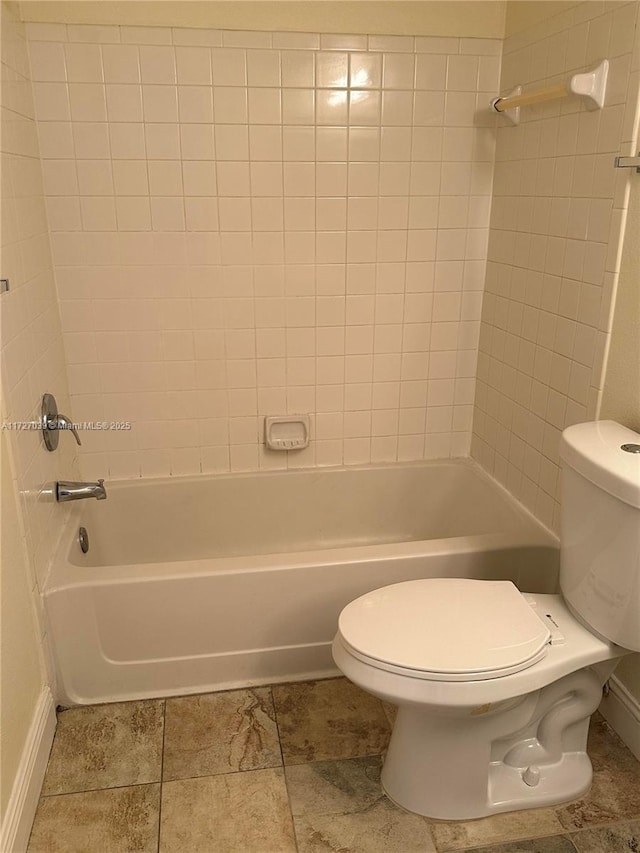 bathroom with toilet and tiled shower / bath combo