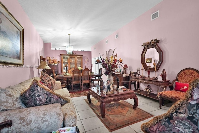 tiled living room with a notable chandelier