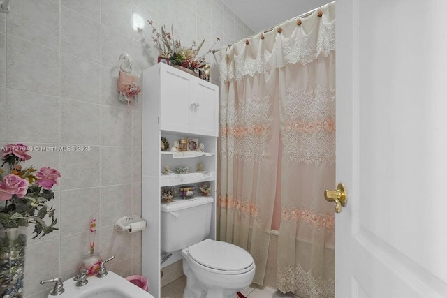 bathroom featuring curtained shower, tile walls, toilet, and a bidet