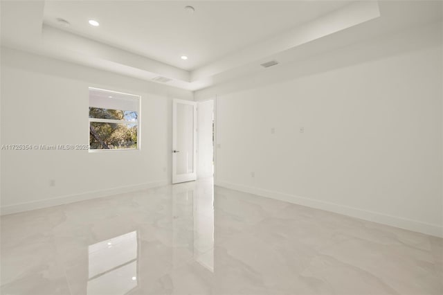 unfurnished room featuring a tray ceiling