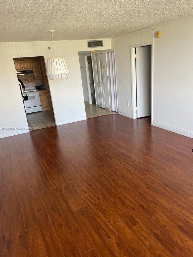 spare room with a textured ceiling and light wood-type flooring