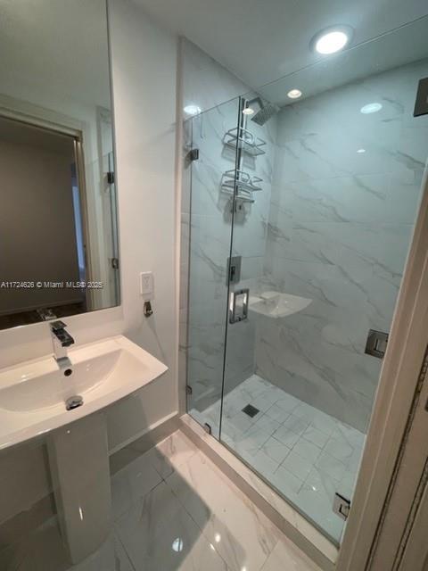 bathroom featuring vanity and a shower with door