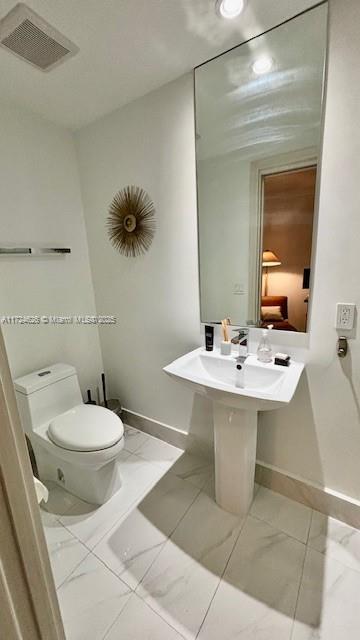 801 S Miami Ave Unit 4706, Miami, FL 33130 - bathroom featuring marble finish flooring, baseboards, and toilet
