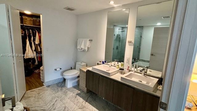 801 S Miami Ave Unit 4706, Miami, FL 33130 - bathroom with toilet, a stall shower, a spacious closet, double vanity, and recessed lighting