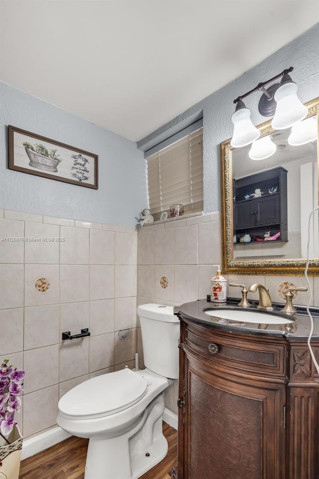 bathroom featuring toilet, tile walls, hardwood / wood-style flooring, and vanity