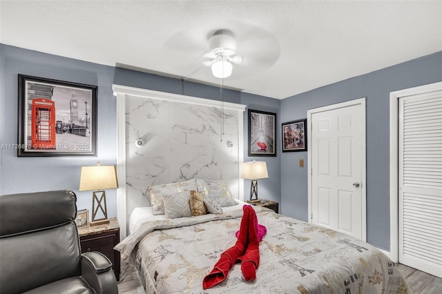 bedroom featuring ceiling fan, two closets, and hardwood / wood-style floors