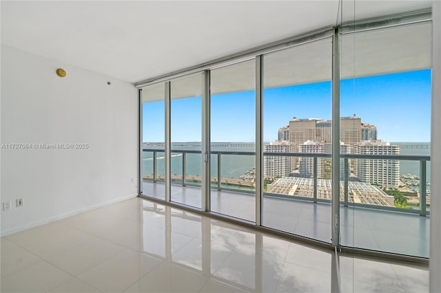 empty room featuring a water view, a healthy amount of sunlight, and floor to ceiling windows