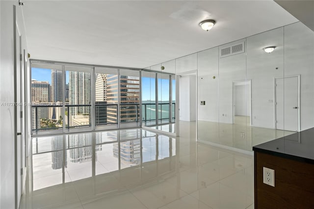 unfurnished room featuring expansive windows and tile patterned floors