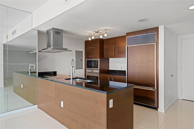 kitchen with built in appliances, extractor fan, sink, kitchen peninsula, and light tile patterned flooring