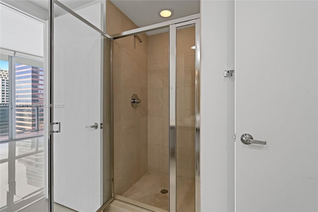 bathroom featuring a wall of windows and a shower with door