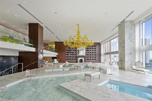 view of pool with a chandelier and a fireplace