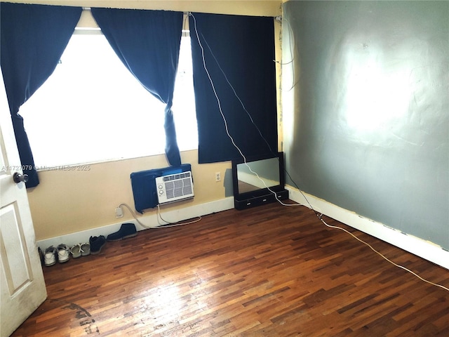 empty room featuring dark hardwood / wood-style floors and a wall unit AC