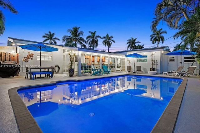 pool at dusk with a patio