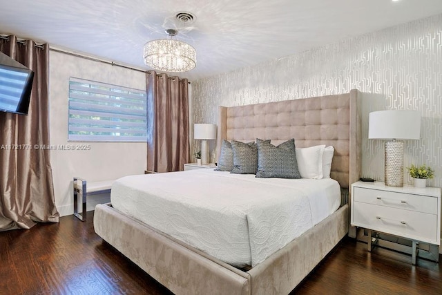 bedroom with dark wood-type flooring and a chandelier