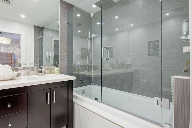 bathroom featuring tasteful backsplash, vanity, and shower / bath combination with glass door