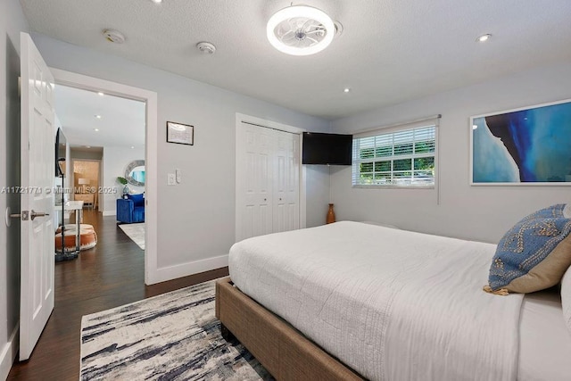 bedroom with dark wood-type flooring and a closet