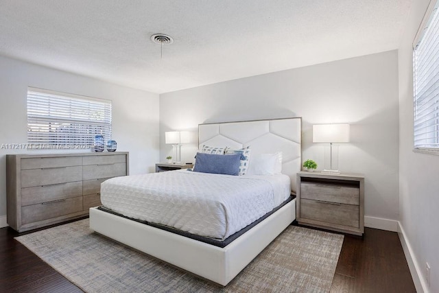 bedroom with dark hardwood / wood-style flooring