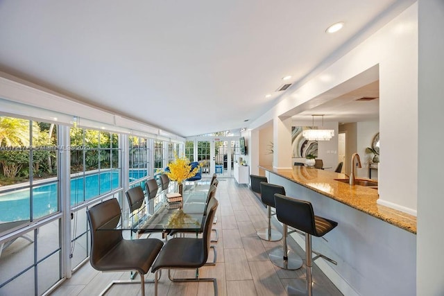 sunroom / solarium featuring sink and an inviting chandelier