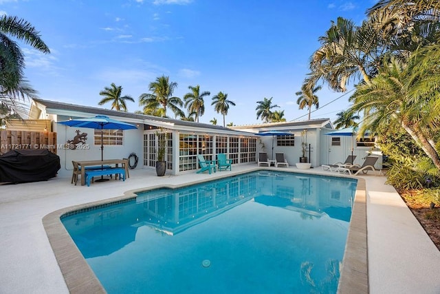 view of pool featuring area for grilling and a patio