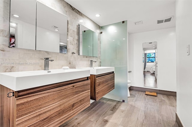 bathroom with toilet, vanity, and hardwood / wood-style floors