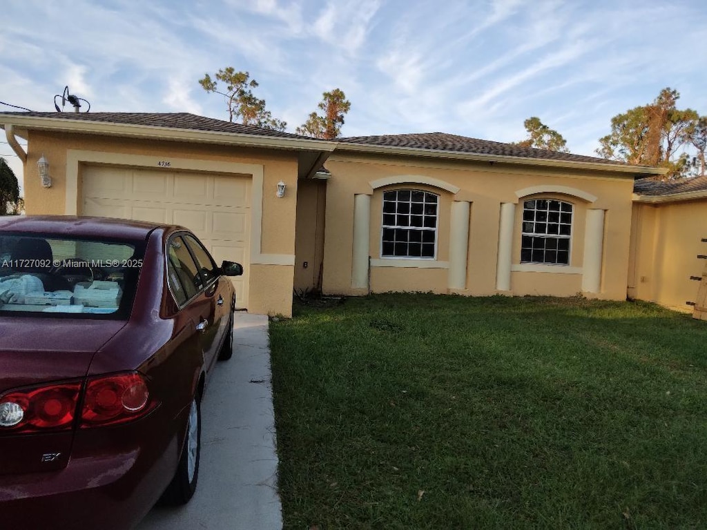 view of front of home with a garage and a front yard