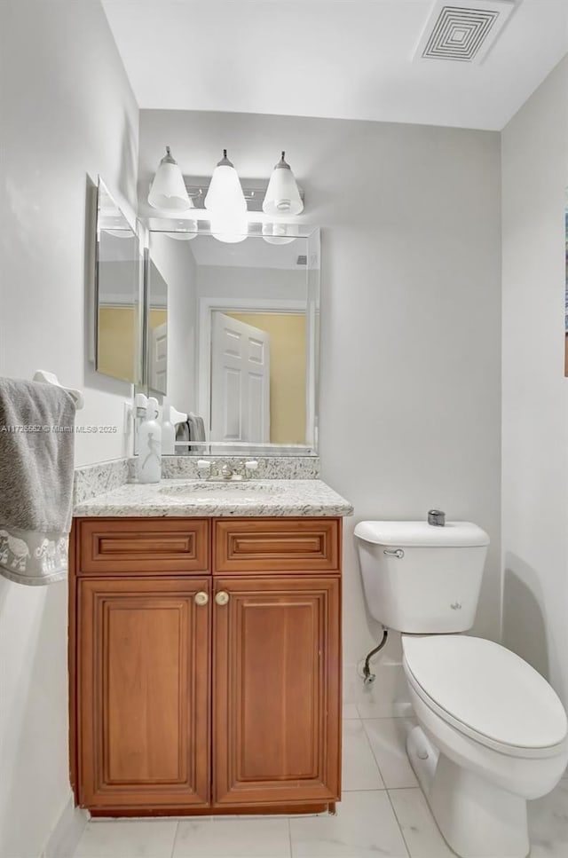 bathroom featuring vanity, tile patterned floors, and toilet