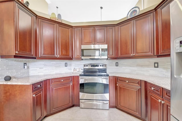 kitchen with light stone counters, light tile patterned floors, backsplash, and stainless steel appliances