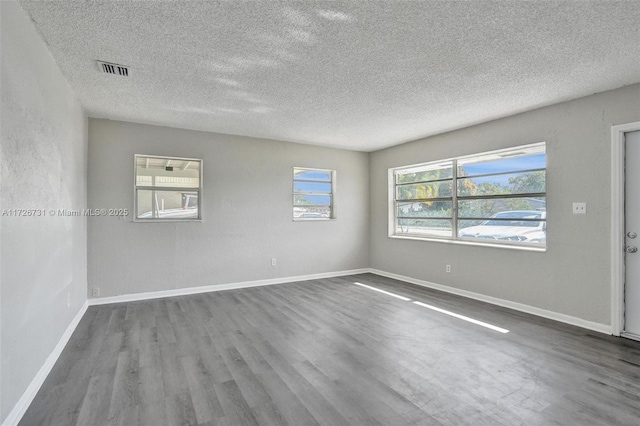 spare room with a textured ceiling and hardwood / wood-style flooring