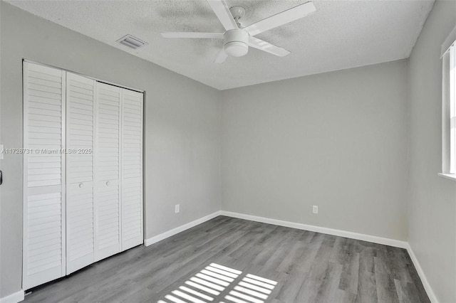 unfurnished bedroom featuring light wood-type flooring, ceiling fan, a closet, and a textured ceiling