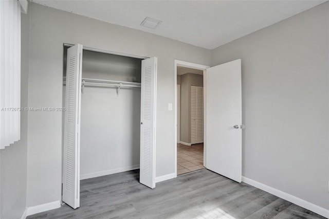 unfurnished bedroom featuring a closet and light wood-type flooring