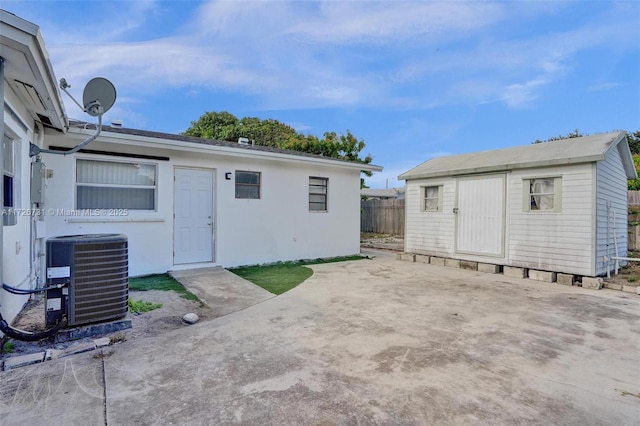 back of property with a patio area, cooling unit, and a storage unit