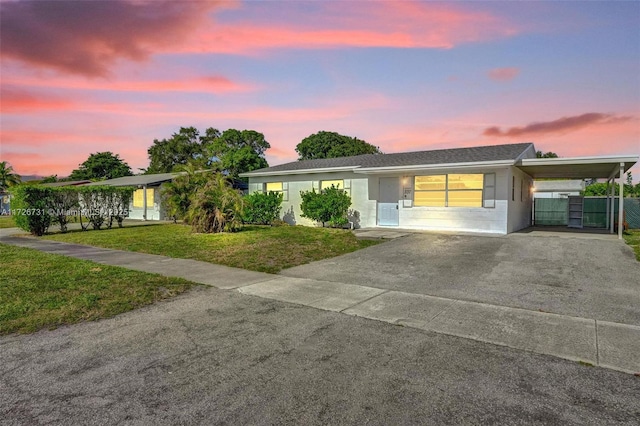 single story home with a lawn and a carport