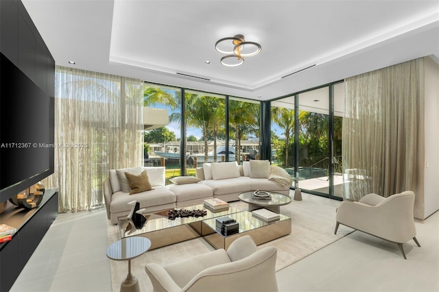 living room with a raised ceiling and expansive windows