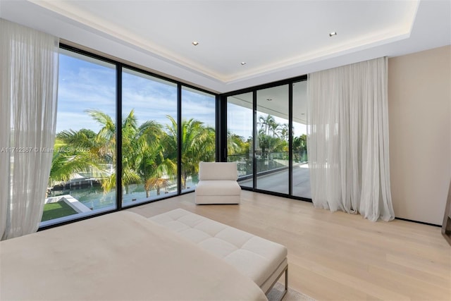 bedroom featuring light hardwood / wood-style floors, access to exterior, and expansive windows