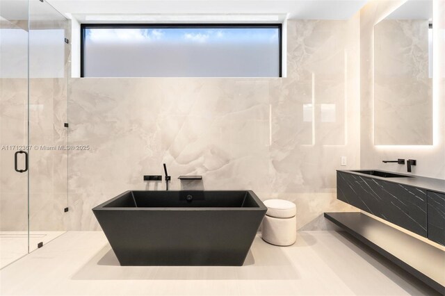 bathroom featuring vanity, tile walls, and plus walk in shower