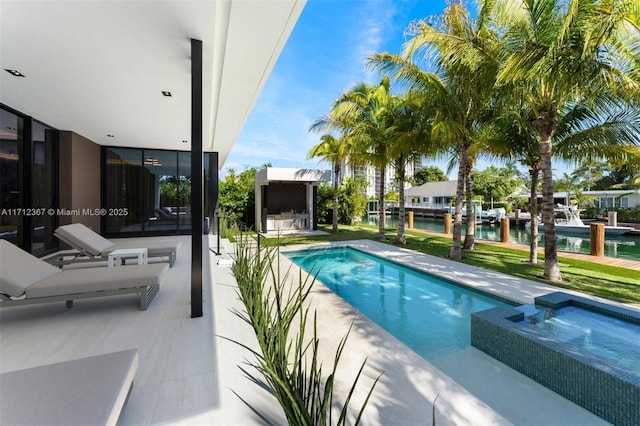 view of pool with a water view, an in ground hot tub, and a patio