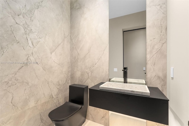 bathroom featuring toilet, tile walls, and vanity