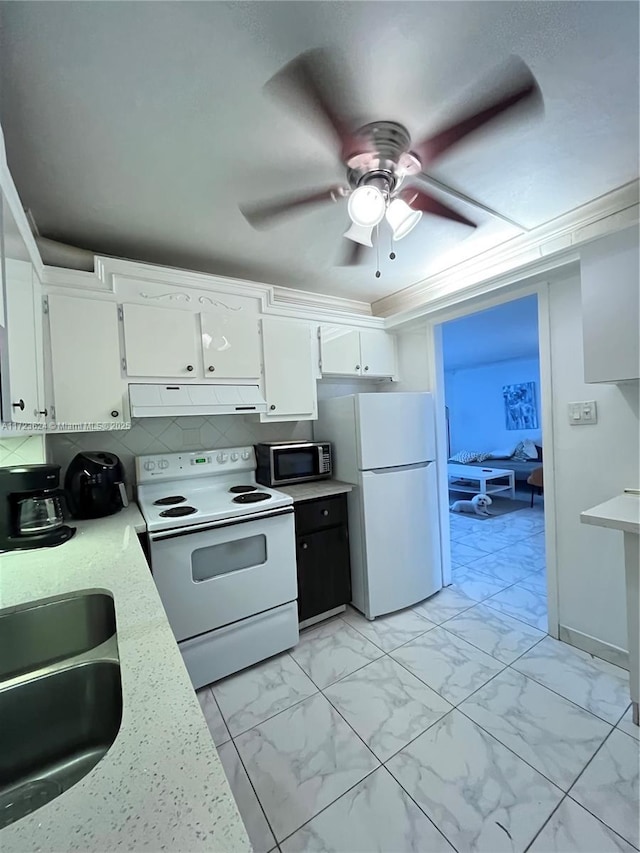 kitchen with white appliances, white cabinetry, tasteful backsplash, sink, and ceiling fan