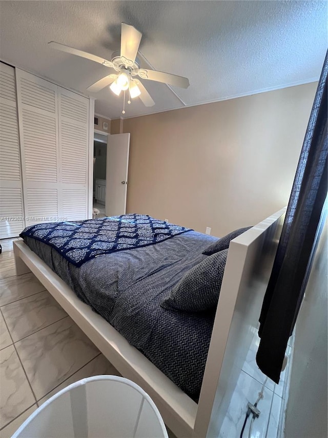 bedroom featuring ceiling fan, a textured ceiling, and a closet